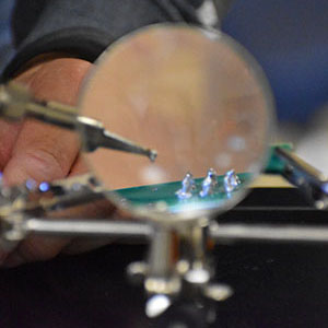 close up picture of a student soldering.