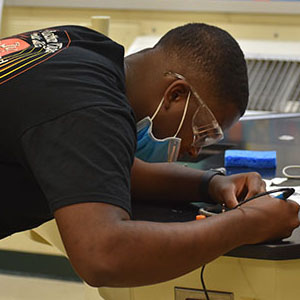 close up picture of a student soldering.