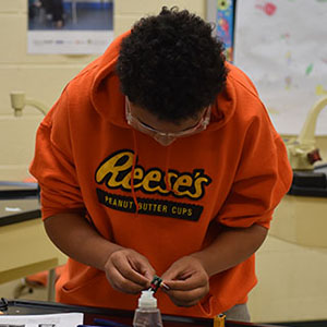 close up picture of a student soldering.