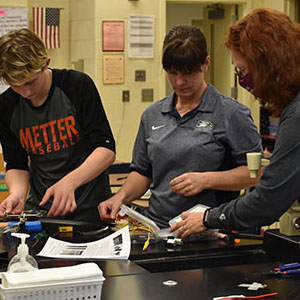 Georgia Southern helpers are reviewing work done by a student